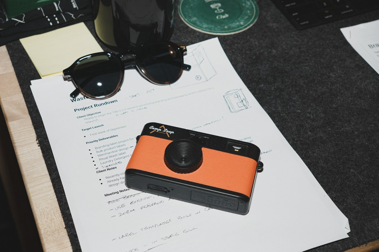 Camp Snap camera and shoot notes on a desk in the Fairwell Collective office