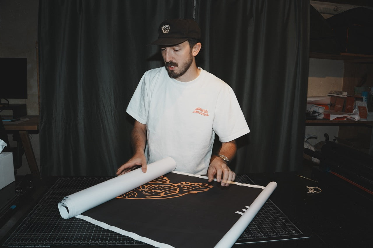 Fairwell Collective team member unrolling a printed brand banner design