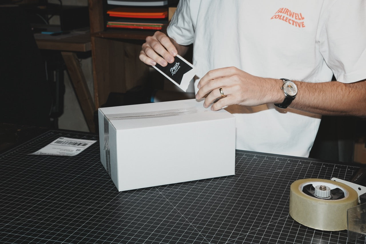 Fairwell Collective team member labeling a shipping box for a hospitality client
