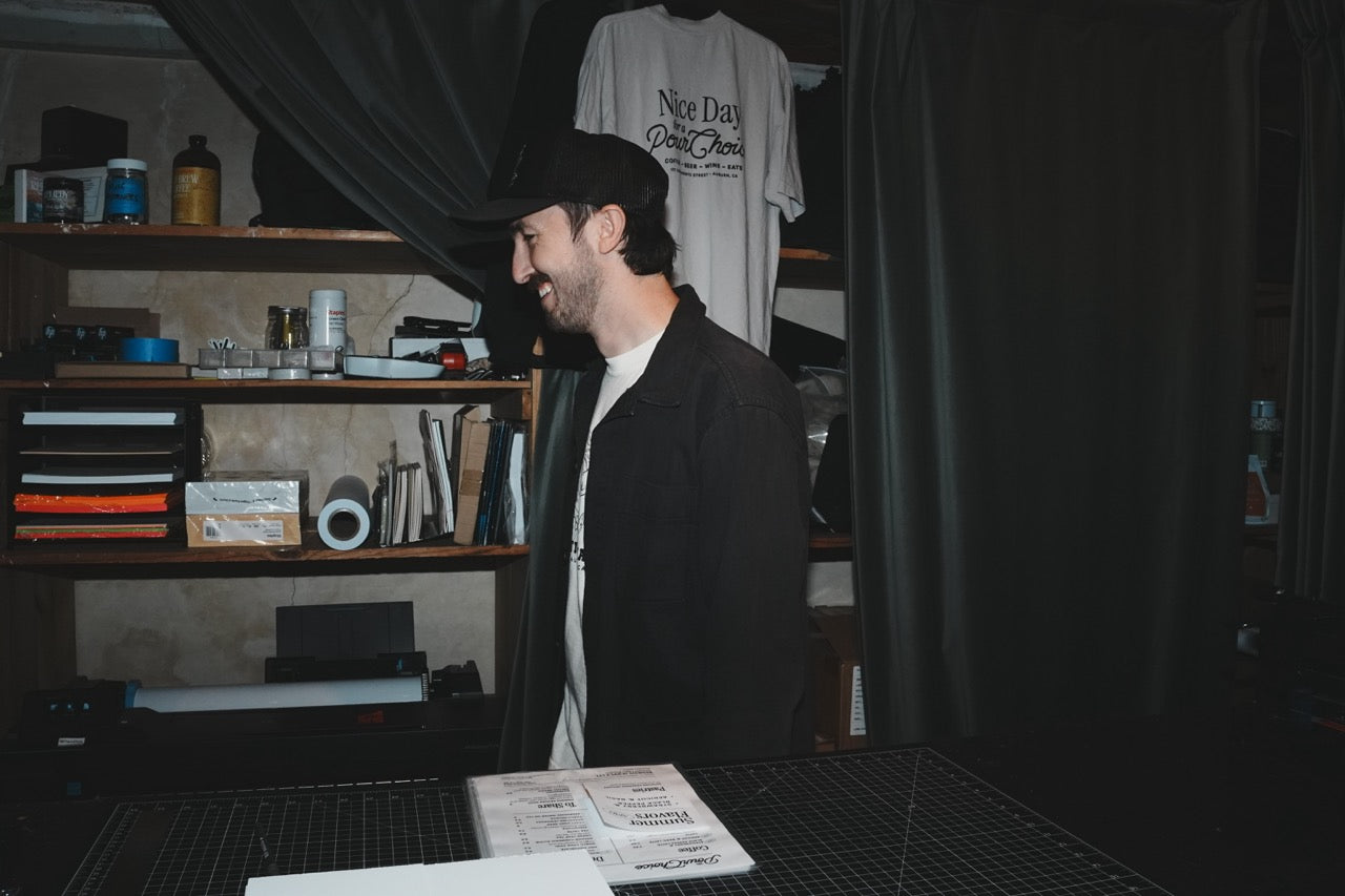 Fairwell Collective team member laughing candidly in front of a branded merchandise display
