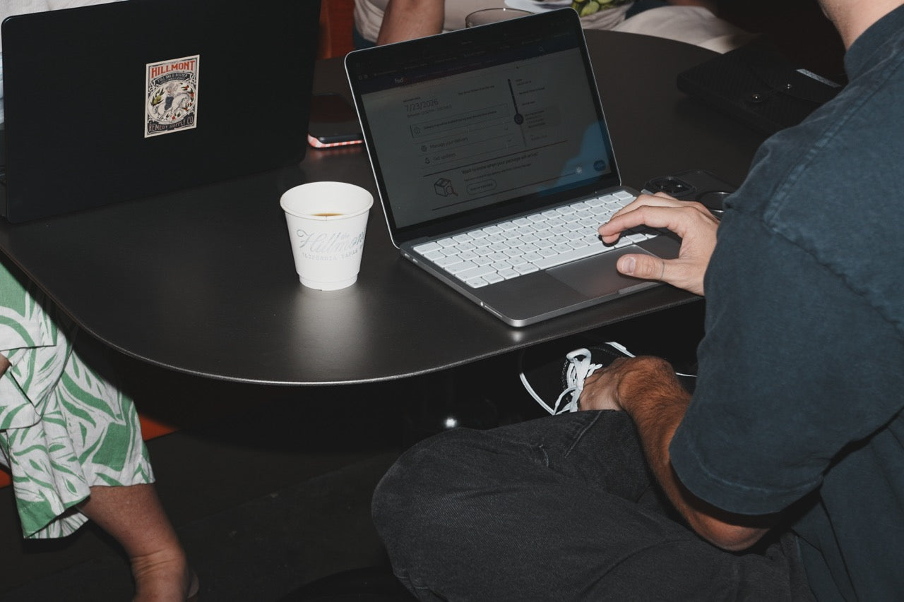 Laptop with a website dashboard next to a branded coffee cup